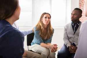 clients sit in a group therapy session in an opioid addiction treatment center