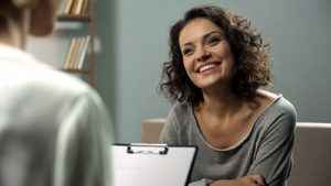 female patient smiles while talking to a therapist in individual therapy program