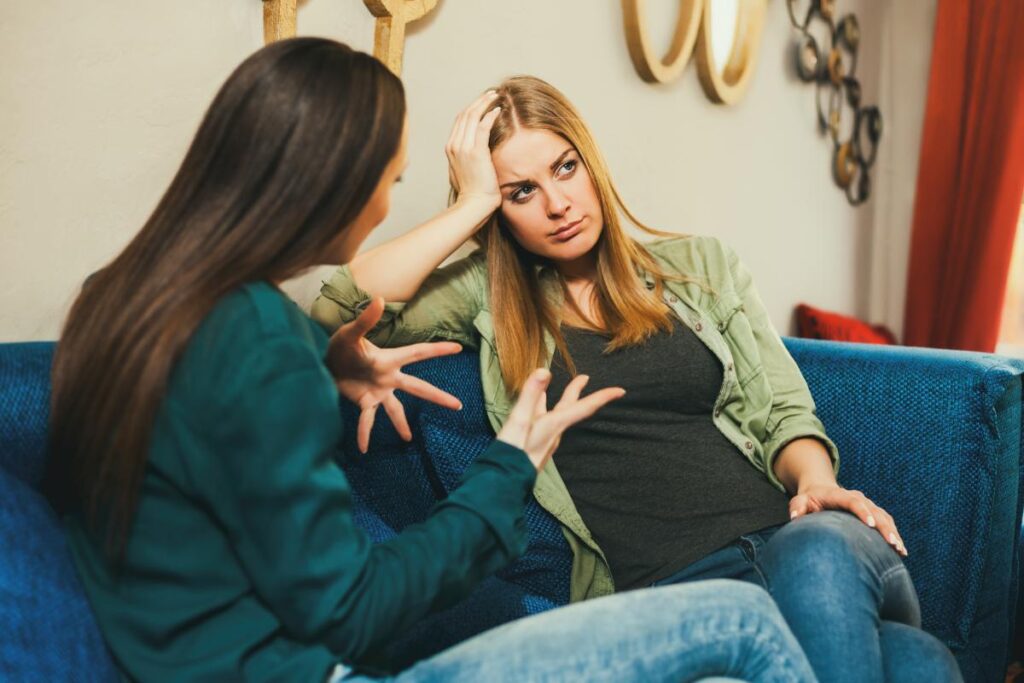 a person explains the myths about drug and alcohol rehab to another while sitting on a couch together