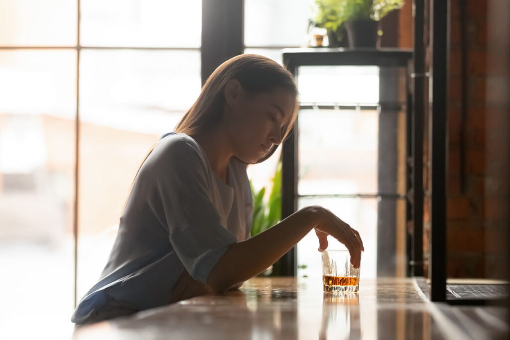 a person sits at a bar possibly with both alcohol and depression