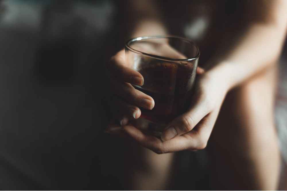 Woman hold a glass thinking about alcohol abuse and alcohol rehab