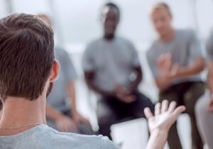 a group of men talk in a men's addiction treatment center