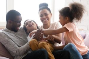 a family smiles with each other after finding help from a family therapy program