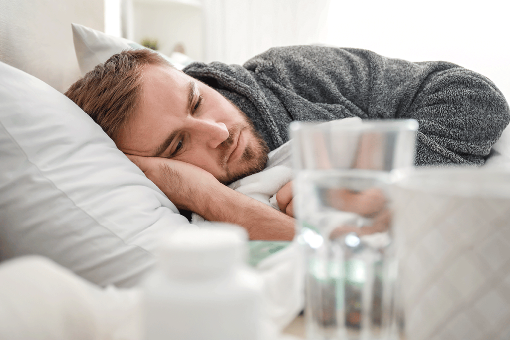 a man feels sick in bed as he attempts to detox from alcohol at home without professional help