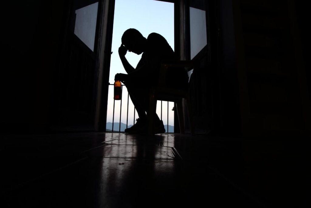 a person in the dark struggles and leans over after learning about the most common alcohol-related injuries