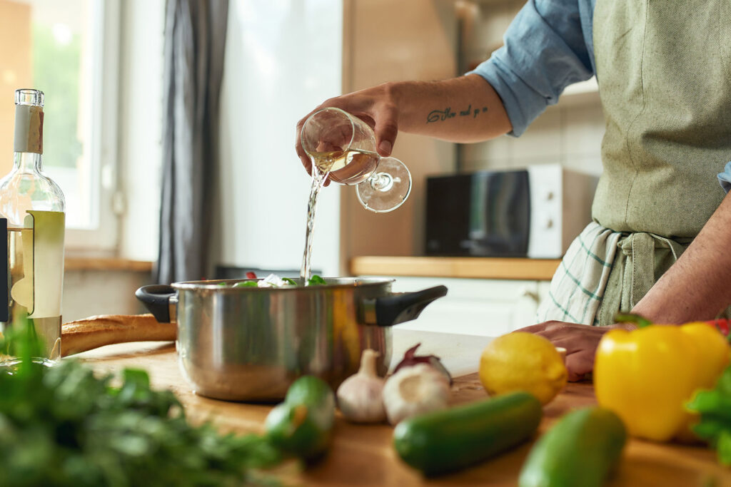 a person pours a glass of wine into a cooking pot and wonders if alcoholic recovery and food cooked with alcohol can mix