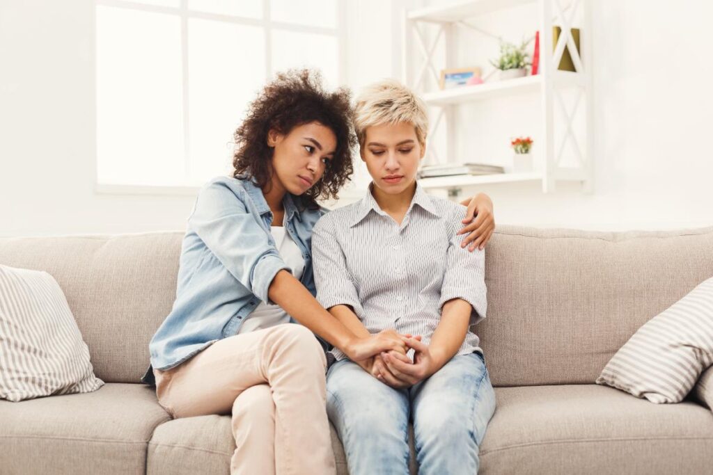 couple sitting on couch with one trying to help the other seek treatment for crack cocaine use