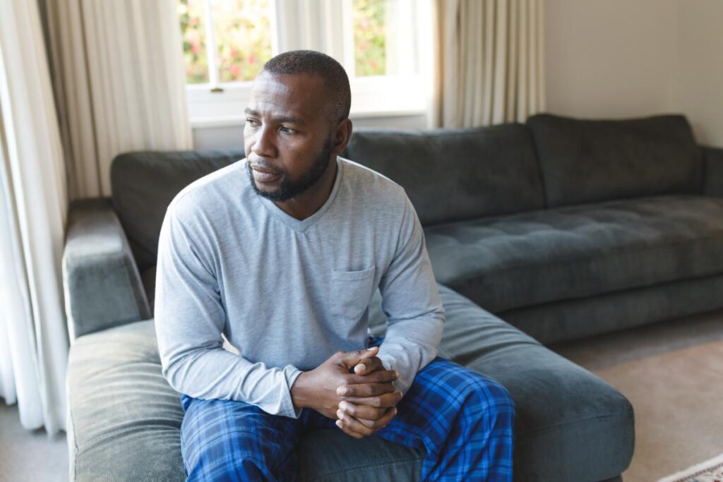 person on couch pensively contemplating dependence vs addiction