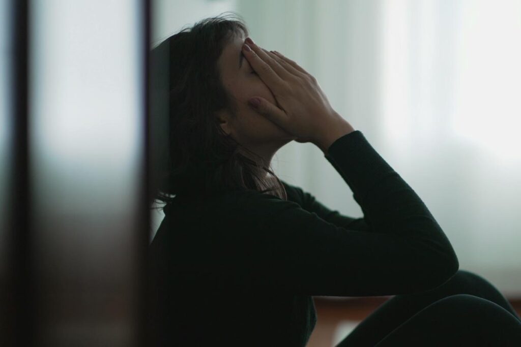 person sitting against wall with hands on face wondering how long does meth stay in your system
