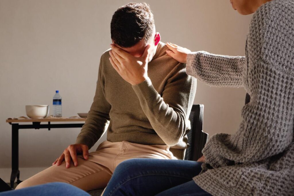 person with hand over face while dealing with the aftermath of a cocaine overdose