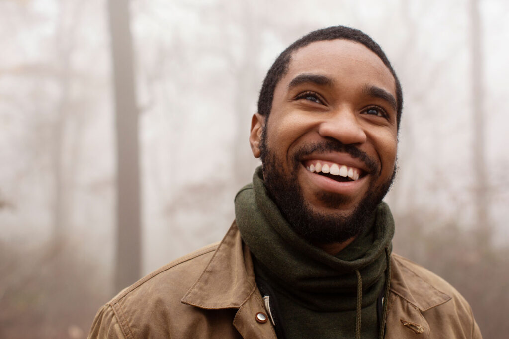 A man is taking a walk outside. It's foggy out and he's smiling. He's been living a sober life after rehab and he's happy now.